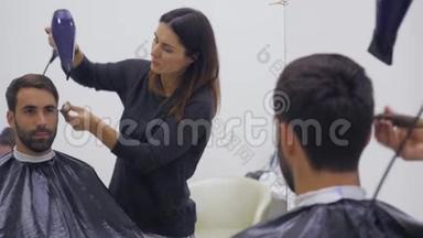 专业美发师在美容院吹风。男青年顾客，女理发师。闭合